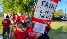 Photo of smiling child and OHNFP member holding sign that says "Fair Contract Now"