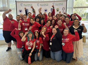 ALC attendees holding a group photo, fist raised in the air!